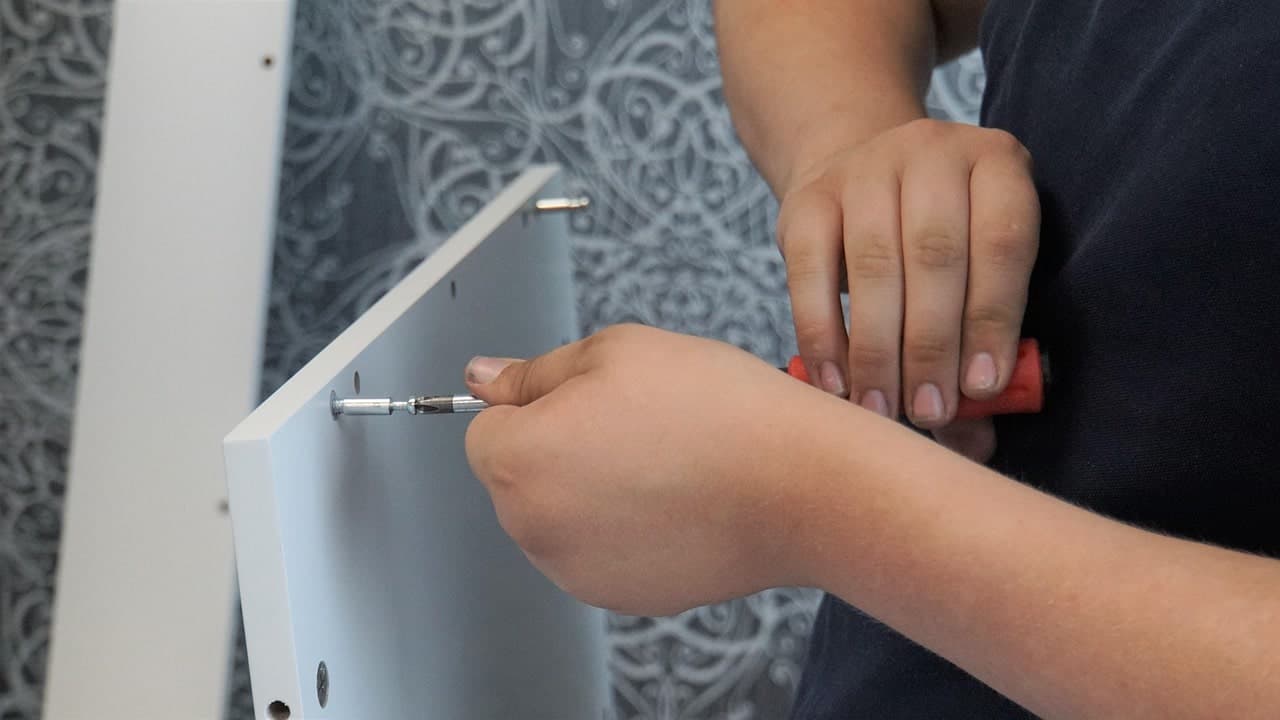 Flat-pack furniture being assembled with tools